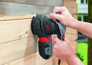 Arbeit des Exzenterschleifers an Holzwand