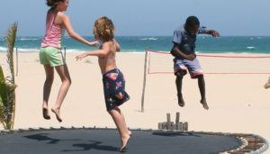 Kinder springen auf einem Trampolin am Strand