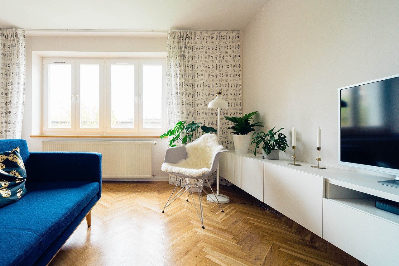 Eingerichtetes Wohnzimmer mit Sofa, Stuhl, Fernseher etc. 